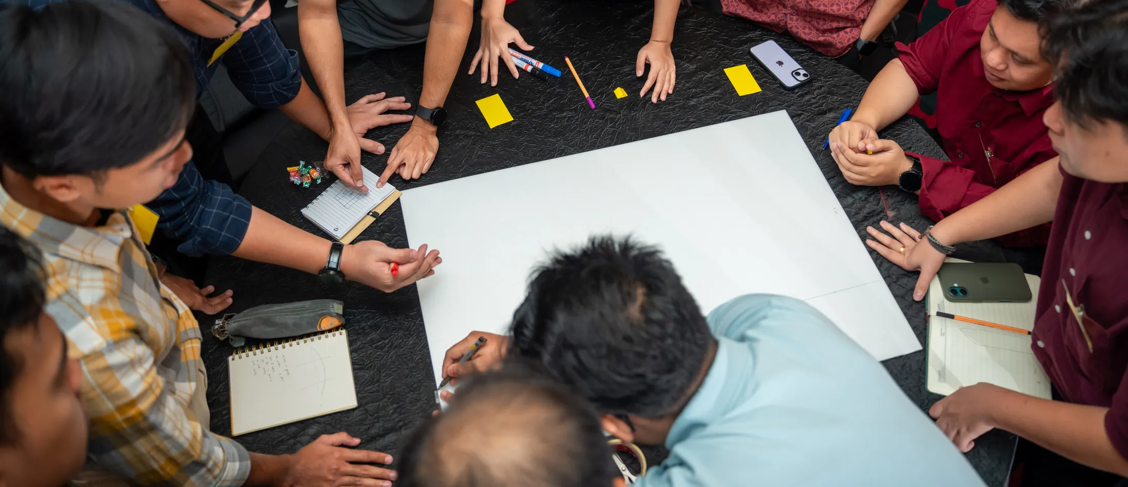A group of professionals working through a hands-on problem-solving exercise together