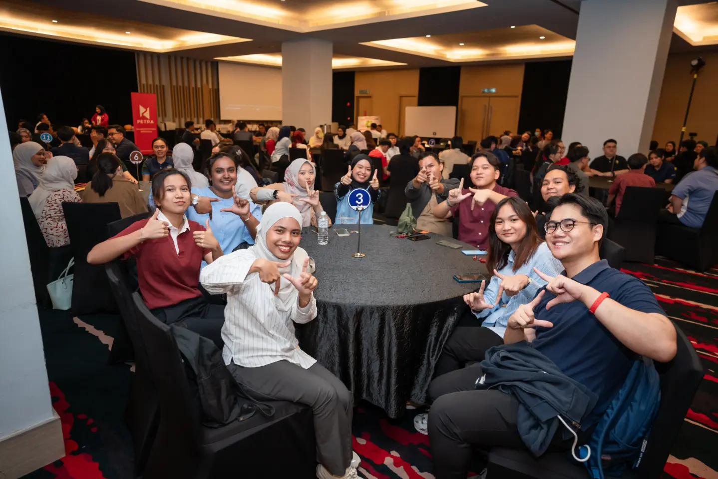 A large cohort of professionals raising their hands during a Learning Edge programme session